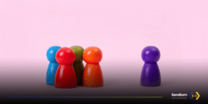 A tight group of four colorful wooden peg dolls stands opposite a single purple peg doll on a pink gradient background, with the Sendium Open Source SMS Gateway logo in the bottom right corner. The dolls emulates the users of the Sendium Community.